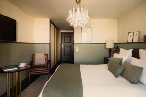 Zimmer im Le Fitz Roy mit Ledersessel, Ankleidebereich und Murano-Glasleuchter