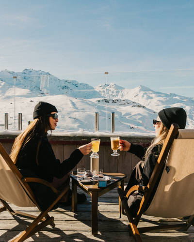 Friends toasting on a sunny après-ski terrace at Val Thorens, Beaumier