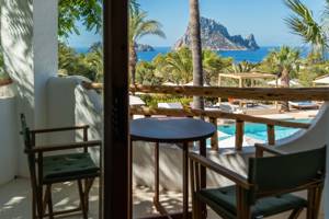 A table with two chairs sits on the resort balcony, offering stunning island mountain views.