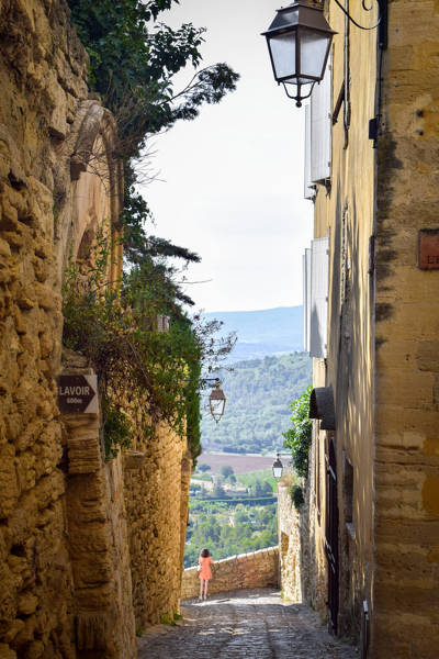Cobblestone alley and valley view in the perched village of Gordes, Luberon