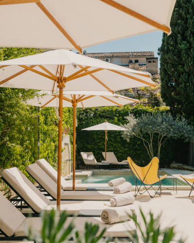 Poolside sun loungers and parasols at the Beaumier hotel Le Moulin in Lourmarin, Luberon