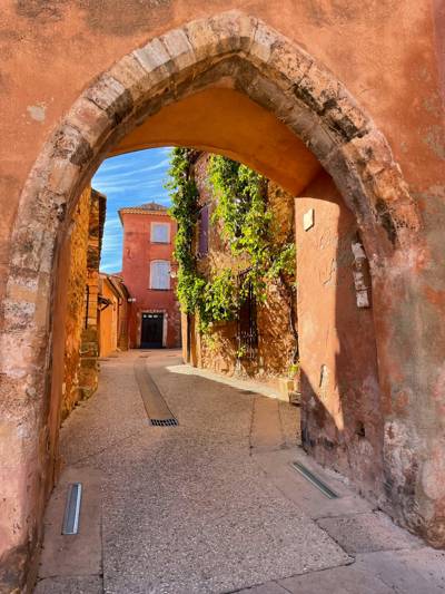 Stone archway opening onto an ochre-walled street in Roussillon, Luberon