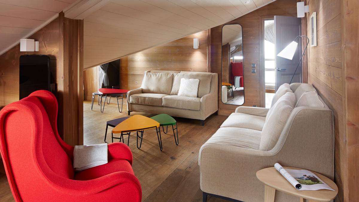 Espace de vie bien organisé avec canapés colorés, confortables et table basse différente proche.