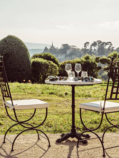 Outdoor dining table with Luberon village view at La Bergerie, gastronomic restaurant at the Beaumier hotel Capelongue in Bonnieux