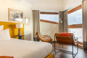 Ambiance chaleureuse de l'espace lit double dans la Suite Val Thorens.