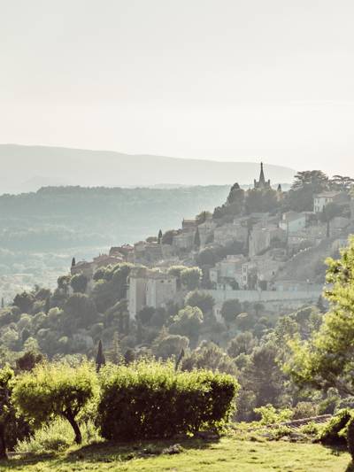 Panoramic view of the hilltop village of Bonnieux in the Luberon, seen from La Bergerie restaurant at Capelongue, surrounded by olive trees and Provençal hills