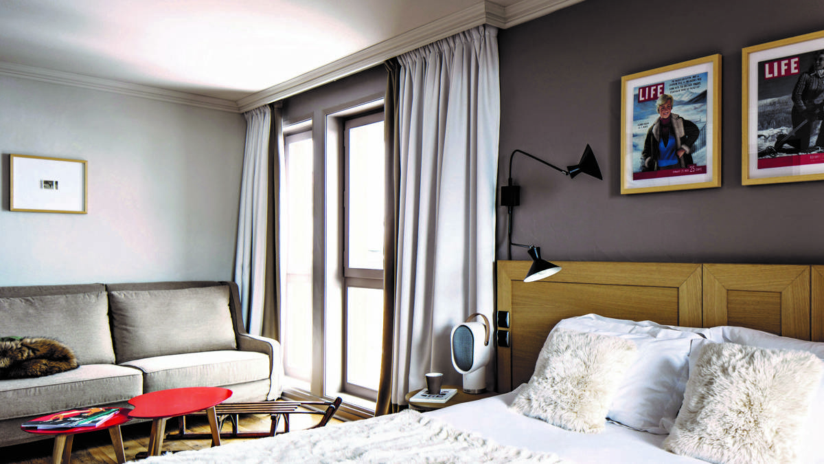 Une chambre bien organisée comprend un lit confortable, un canapé confortable et deux portraits au-dessus.