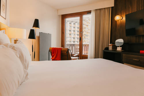 Lit double principal en chambre Privilège avec vue village.