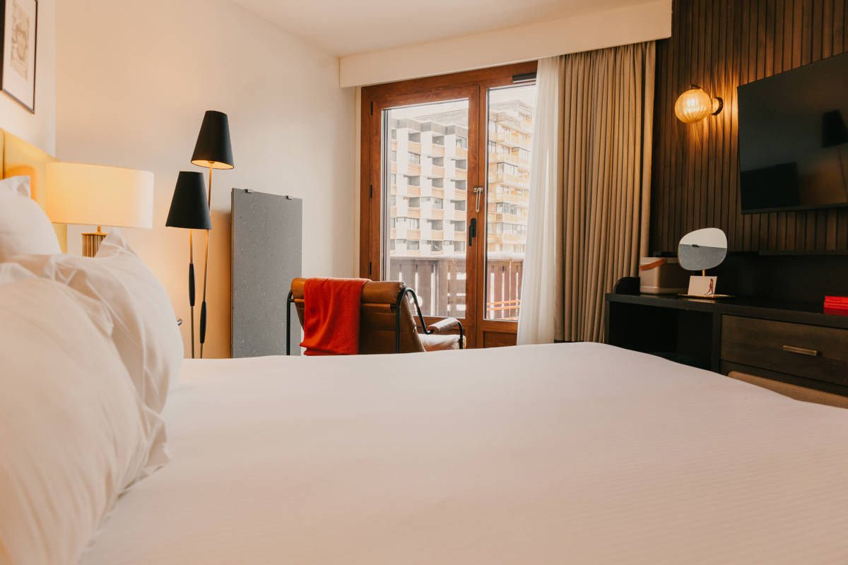Lit double principal en chambre Privilège avec vue village.