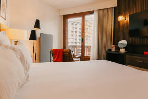 Lit double principal en chambre Privilège avec vue village.